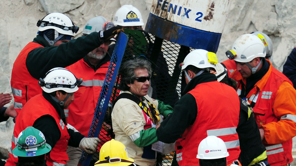 Mario Gómez, uno de los 33 mineros, es ayudado a salir de la cápsula Fénix 2 tras su ascenso a la superficie