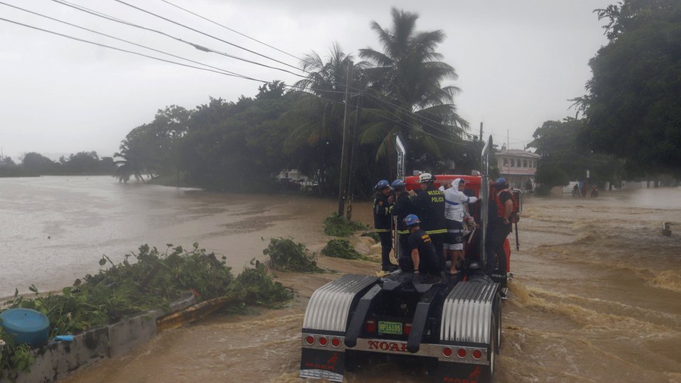 Imágenes de un camión de bomberos mientras cruza un área inundada en Puerto Rico.