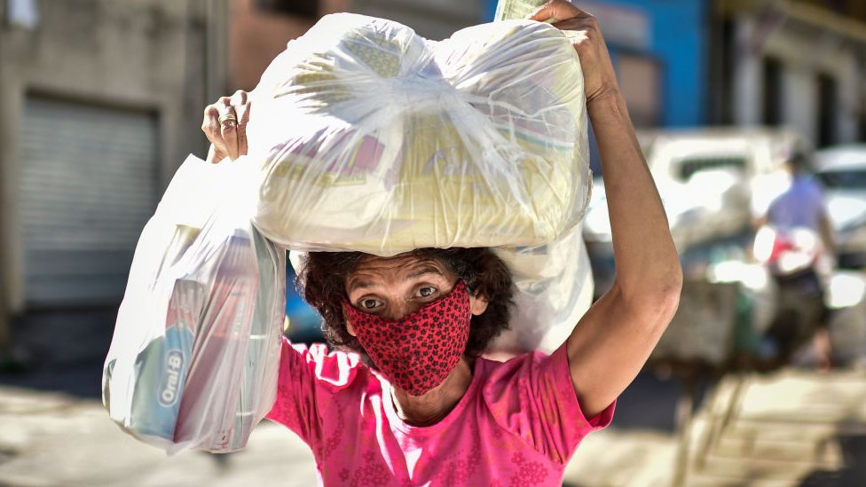 Женщина, бедная жительница фавелы Серра-Агломерадо, получает продукты в Белу-Оризонти