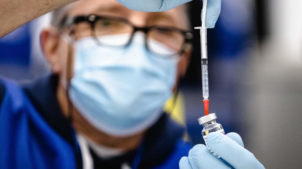 Dutch health workers fills syringe with vaccine