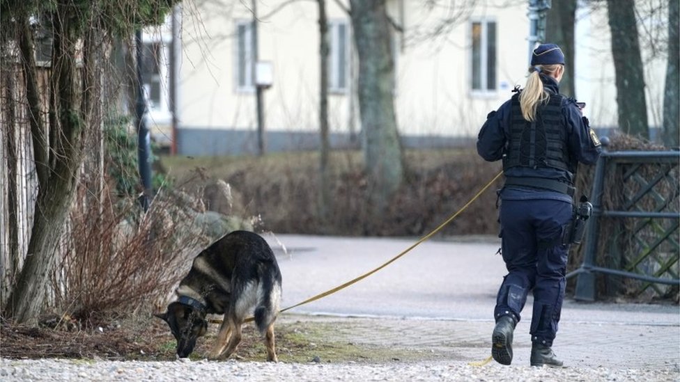 Police officer with a dog patrols at a knife attack site in Vetlanda, Sweden March 3, 2021