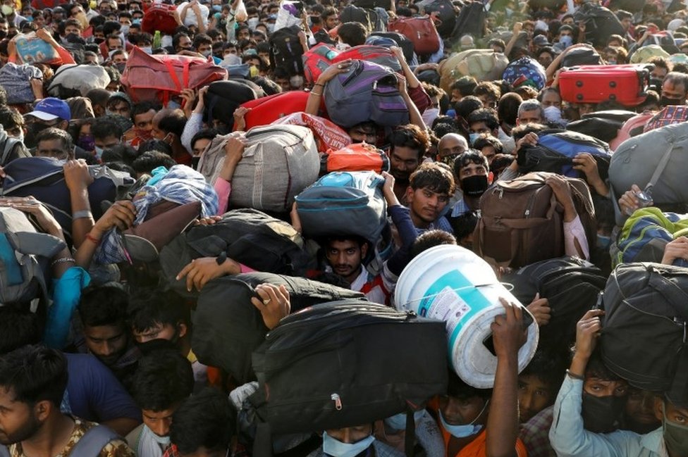 Рабочие-мигранты пытаются найти свои дома в столице Индии во время общенациональной блокировки, введенной правительством