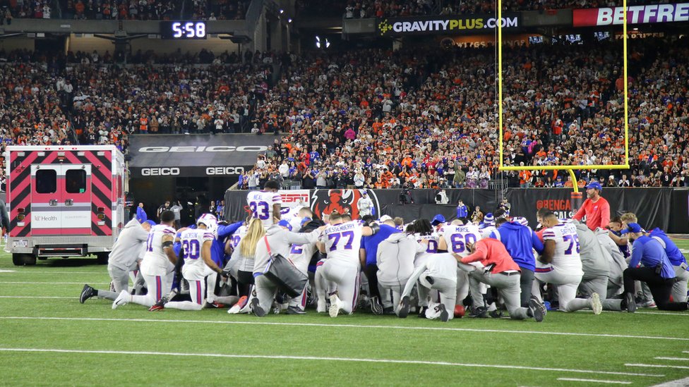 Los jugadores de los Buffalo Bills se arrodillan para rezar mientras la ambulancia se lleva a su compañero Damar Hamlin.