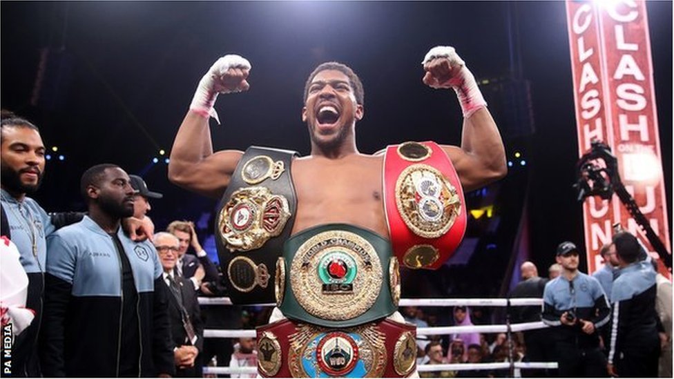 Anthony Joshua celebrates with im belts for ring after im beat Andy Ruiz Jr.
