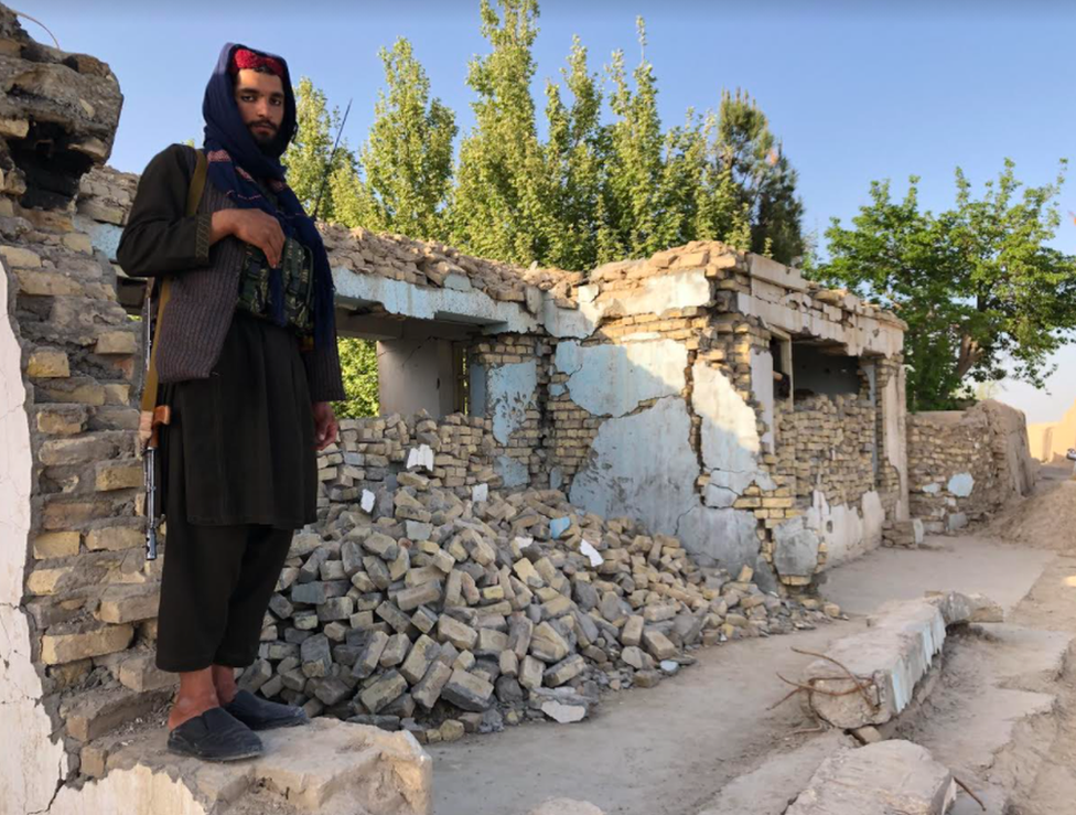 Combatente do Taleban do lado de fora de uma mesquita bombardeada em ataque aéreo