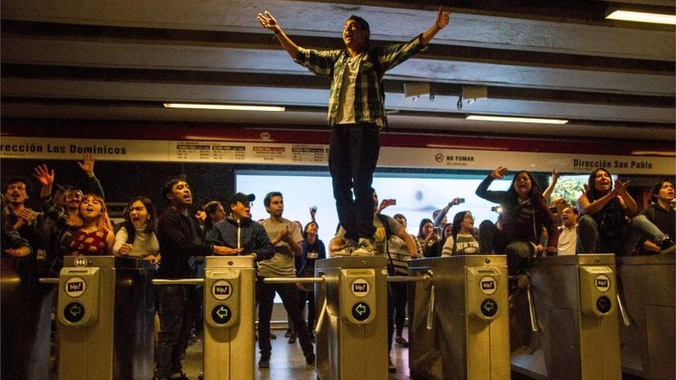 Студенты проводят демонстрацию на станции метро Los Heroes во время массовой акции протеста против неуплаты проезда в Сантьяго, Чили, 18 октября 2019 г.