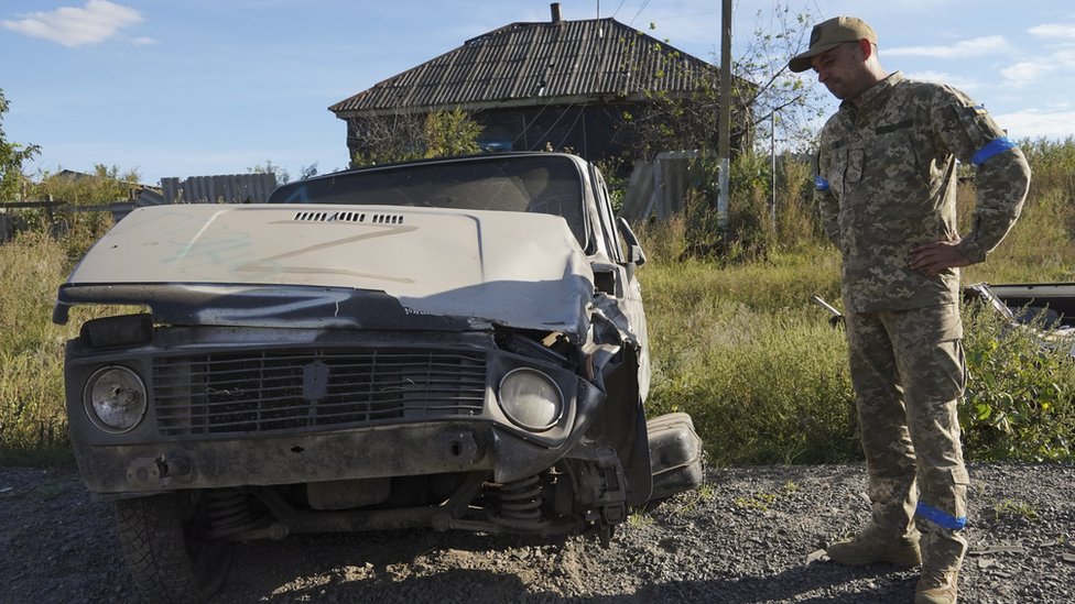 Un soldado ucraniano junto a un vehículo ruso capturado