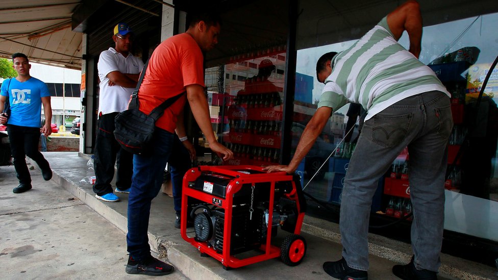 Venezolanos prueban un generador afuera de un supermercado.