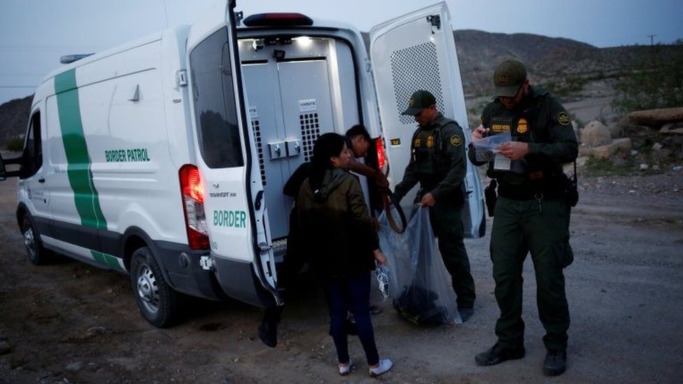 Oficiales de la patrulla fronteriza y un migrante