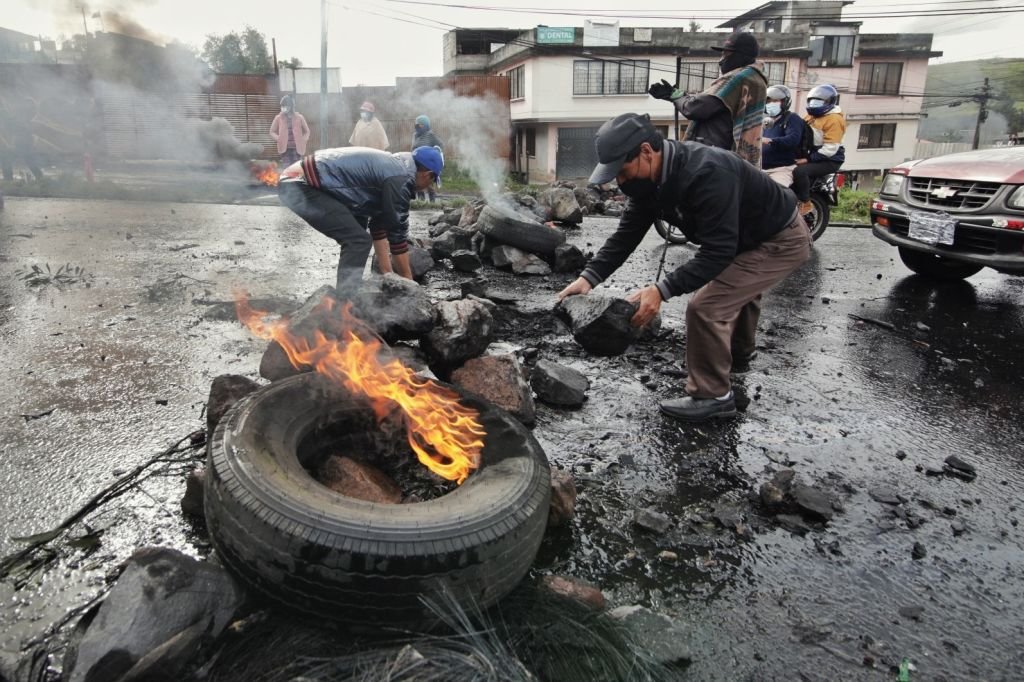 Personas encienden unos neumáticos en medio de una protesta en Quito, Ecuador.