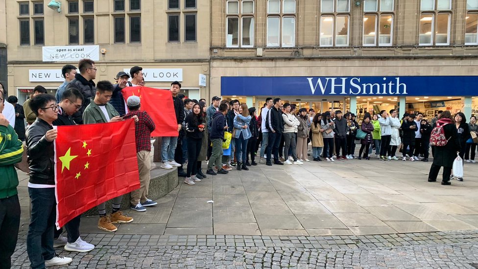 Протестующие держат китайские флаги