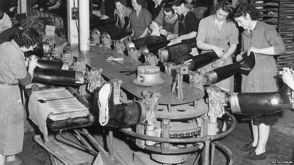 Рабочие производственной линии шьют резиновые сапоги на заводе North British Rubber Company в Эдинбурге