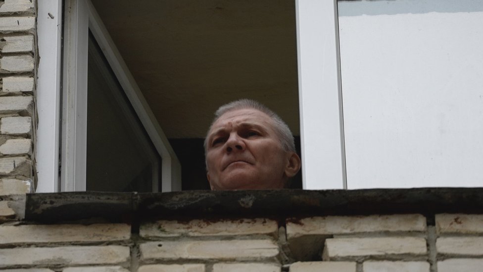 Alexei Moskaleva appears at a window of the building where he is being held under house arrest