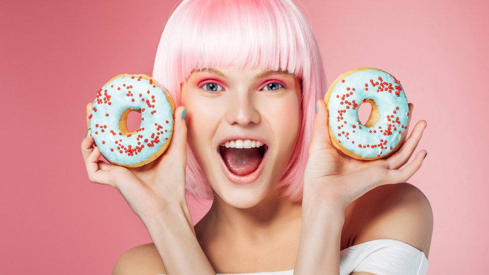 Mujer joven con dos donuts