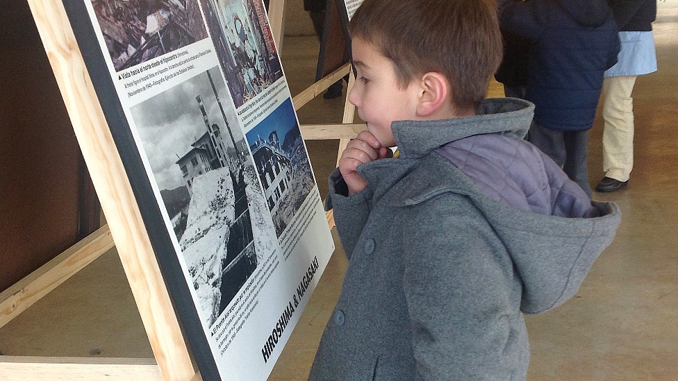 Un niño mira ensimismado un cartel sobre la bomba de Hiroshima en una exposición en Valdivia, Chile