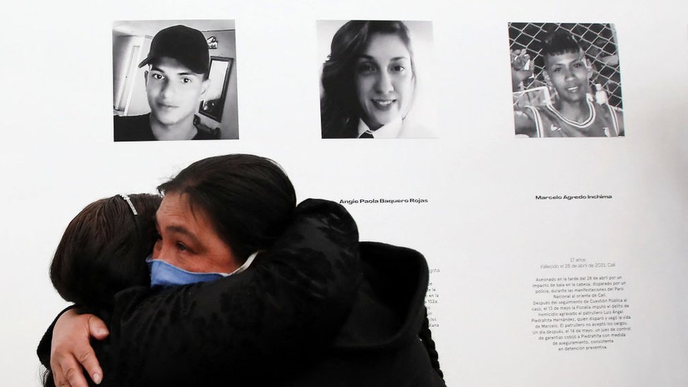 Dos madres de víctimas de las protestas contra la brutalidad policial se abrazan frente a las fotos de sus hijos, 2 de junio de 2021