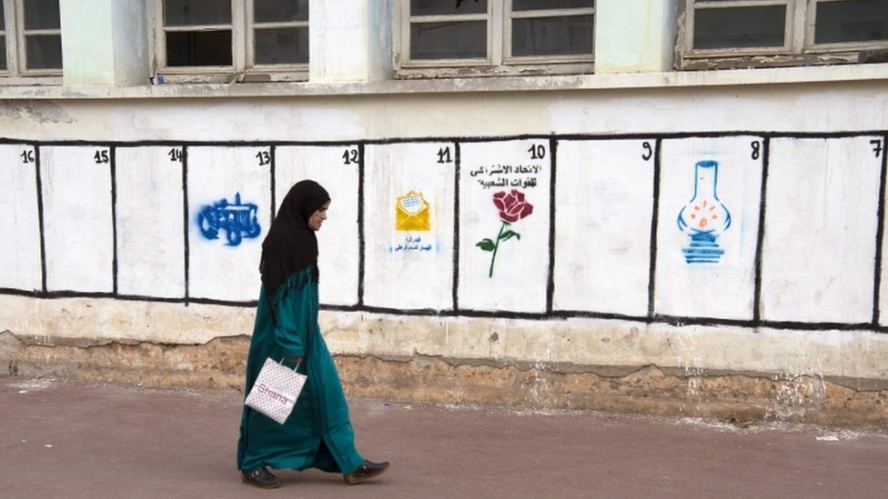 Женщина проходит мимо партийных символов на стене в Рабате, 7 октября 2016 г.