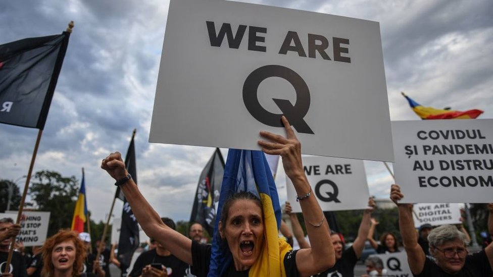 Mulher com cartaz em que se lê: Somos o Q