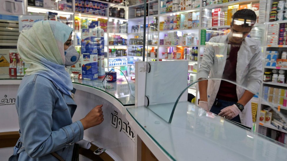Женщина в защитной маске делает покупки в аптеке в Тегеране, Иран (24 февраля 2020 г.)