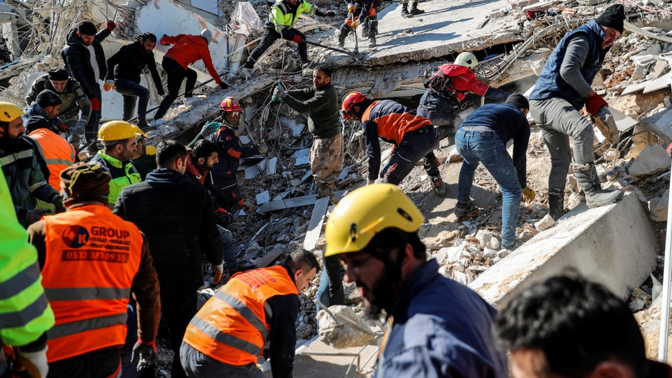 Rescuers search a collapsed building