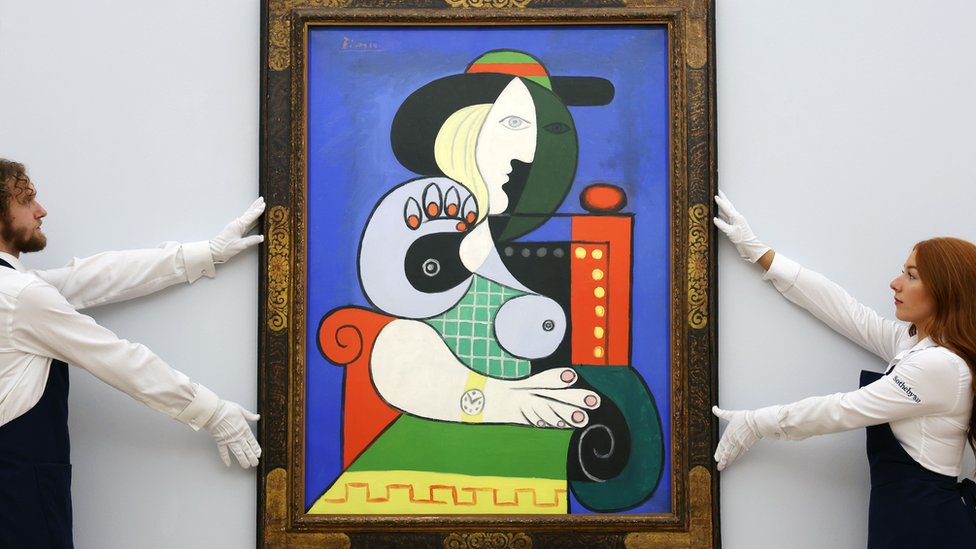 Sotheby's auction house staff with Pablo Picasso's 'Femme a la montre' (1932