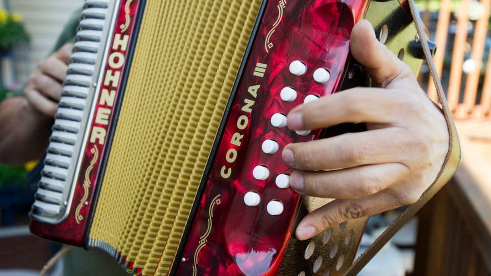 Manos tocando un acordeón