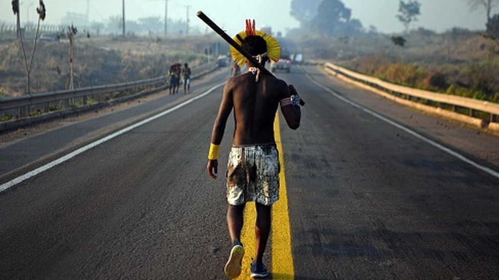 Indígena andando por estrada