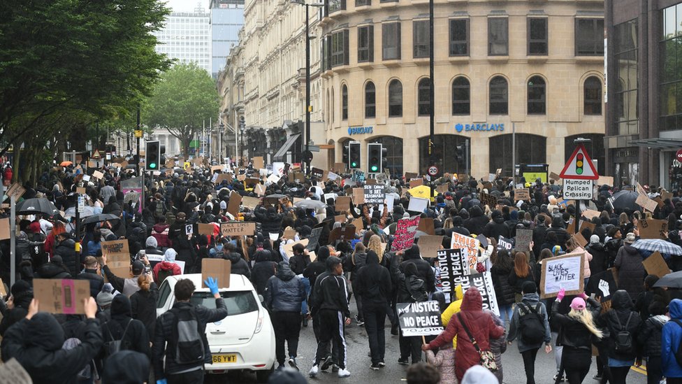 Люди идут по Колмор Роу во время митинга протеста Black Lives Matter в Бирмингеме
