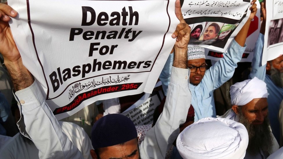 Жесткие протестующие держат транспаранты с требованиями смерти богохульников в Карачи, Пакистан (12 октября 2018 г.)