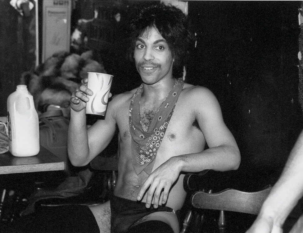 Принц потягивает апельсиновый сок за кулисами во время турне Dirty Mind, 1981