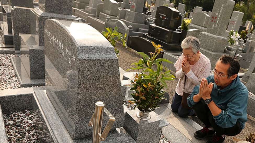 Una mujer y un hombre en Japón realizan una ceremonia para honrar a sus antepasados.
