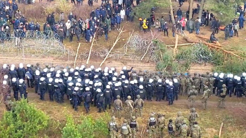 Migrantes y policías en la frontera entre Polonia y Bielorrusia.