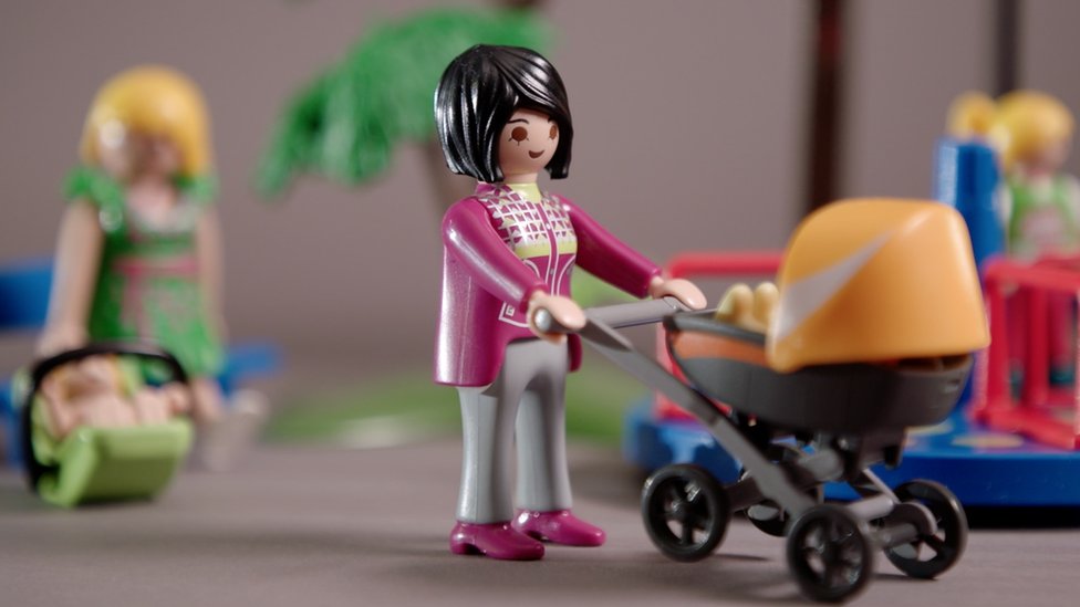 Representación de una madre con muñecos.