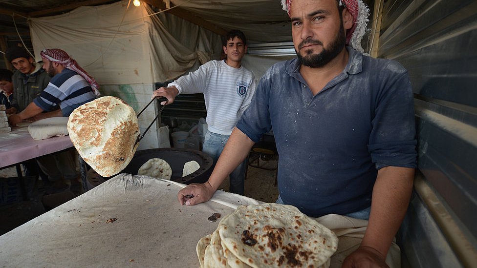 Un refugiado prepara pan para vender en su negocio en el campamento de refugiados de Zaatari