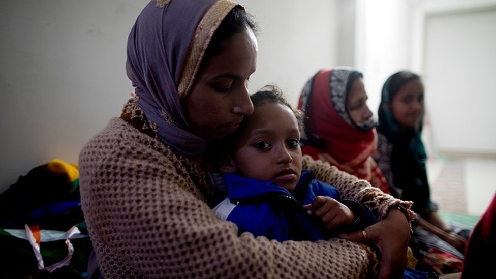 A woman holds her daughter at Al-hind Hospital where they have taken shelter with other families after losing their homes following sectarian riots over India's new citizenship law, in Delhi, 28 February