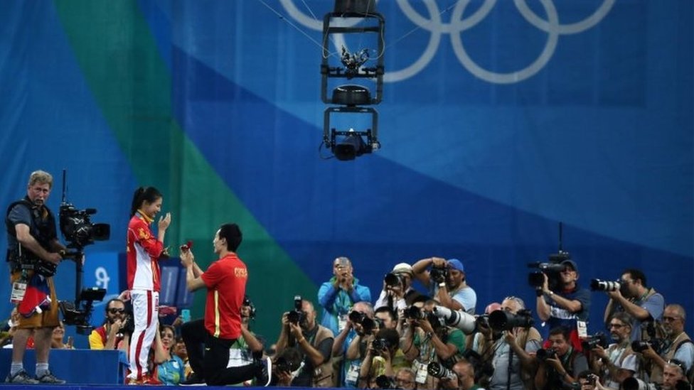 Хэ Цзи (CHN) из Китая получает предложение руки и сердца от олимпийского прыгуна Qin Kai (CHN) из Китая после церемония награждения
