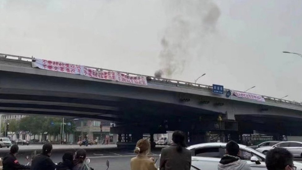 Una pancarta en protesta contra Xi Jinping sobre un puente.