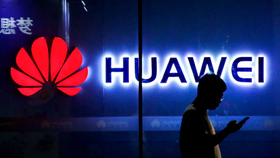 Logo de Huawei y persona caminando