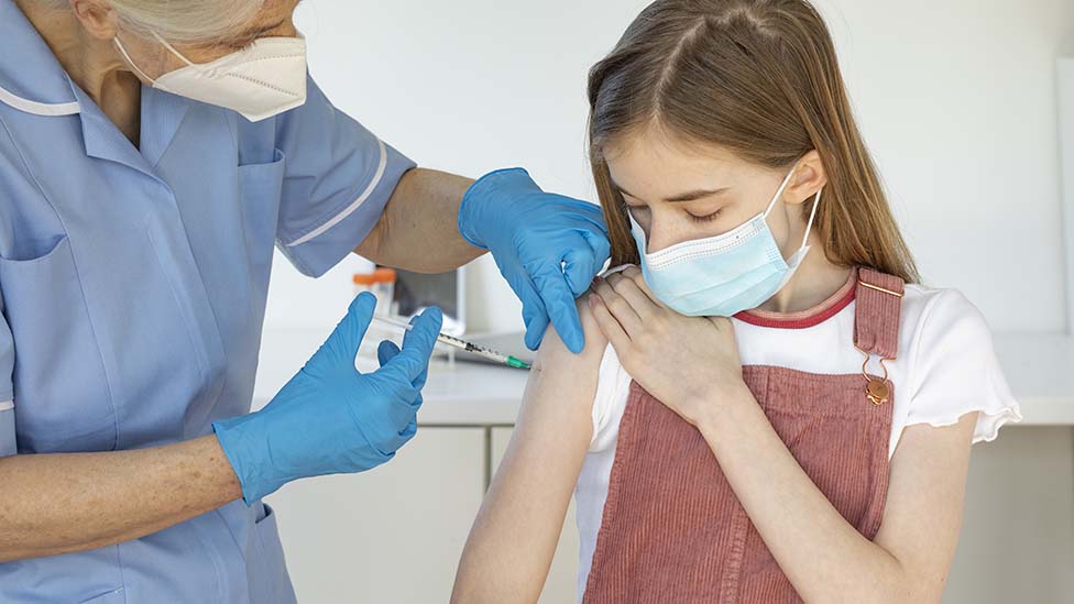 Garota sendo vacinada por enfermeira
