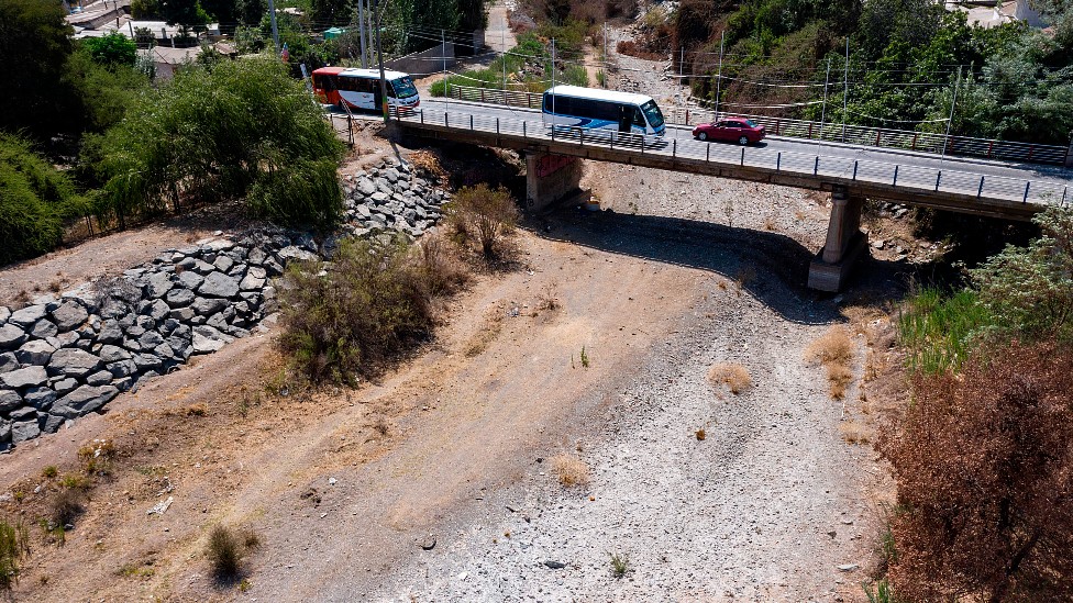 Vehículos cruzando un puente sobre el río Melón seco en Chile