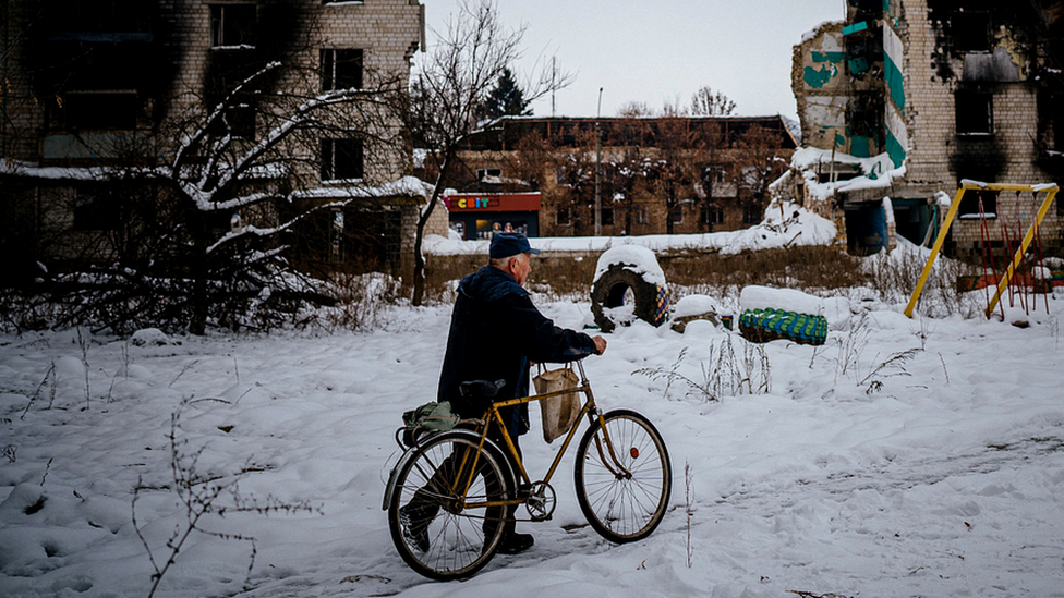 Man with bike on a snow covered street in Borodyanka, near Kyiv on 4 December