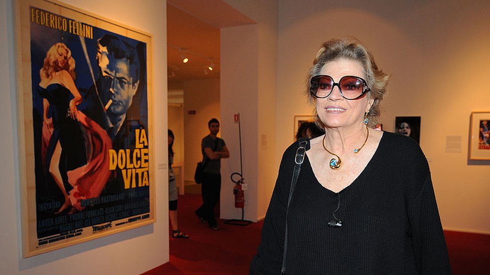 Anita Ekberg frente a un afiche de La Dolce Vita, durante una exposición celebrando a Federico Fellini