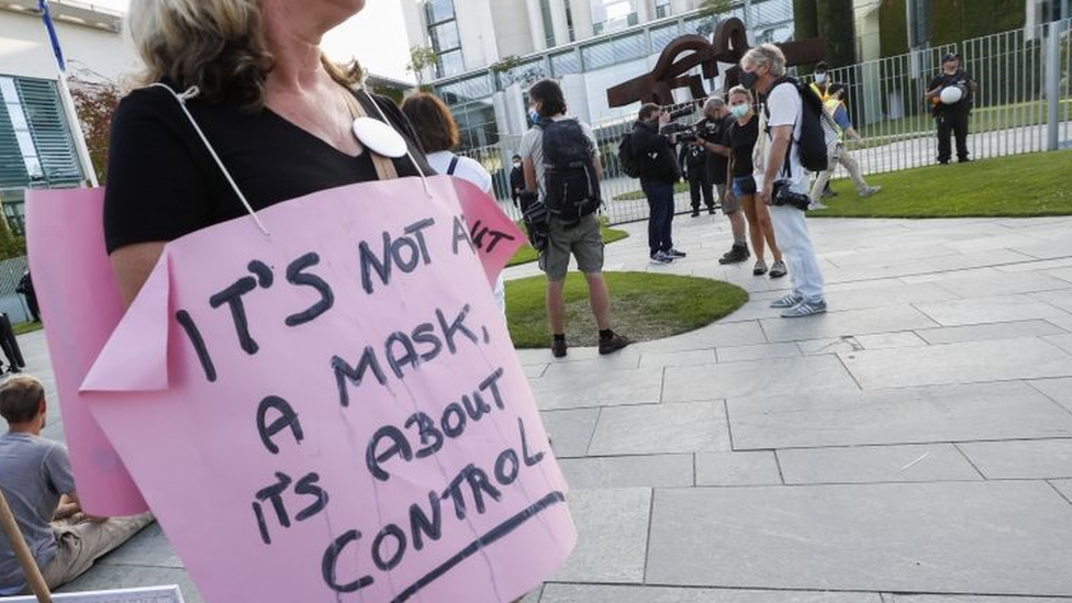 "No es sobre la mascarilla, es sobre control", se lee en la pancarta que porta una manifestante en Alemania.