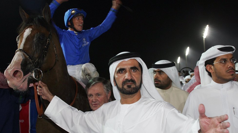 Шейх Мохаммед Аль Мактум держит уздечку Electrocutionist после того, как тот выигрывает чемпионат мира в Дубае, что празднует жокей Фрэнки Деттори (25 марта 2006 г.)