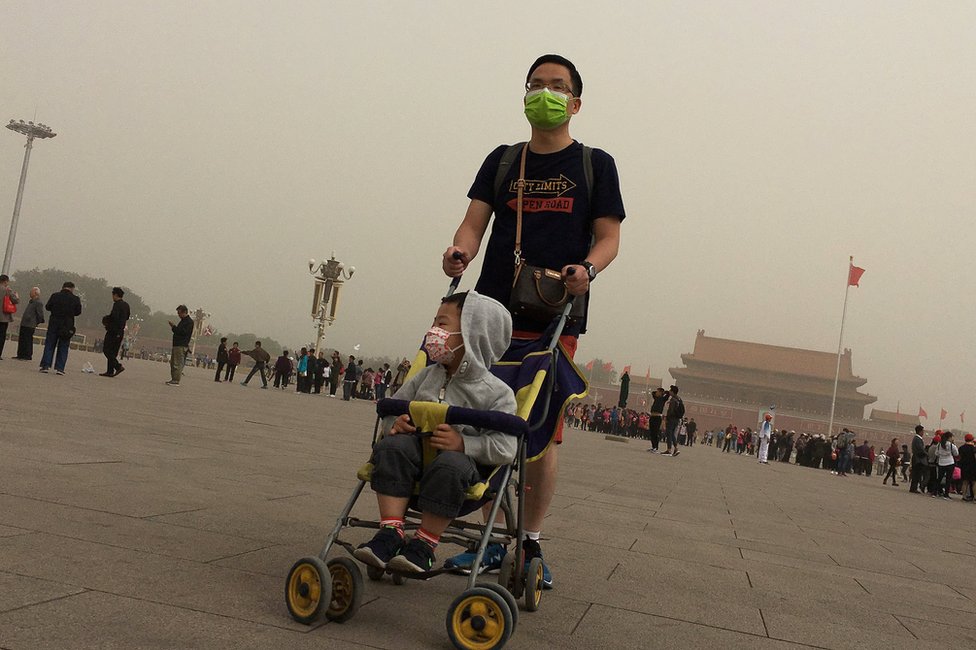 Люди посещают площадь Тяньаньмэнь, когда в Пекин, Китай, 4 мая 2017 года обрушилась пыльная буря.