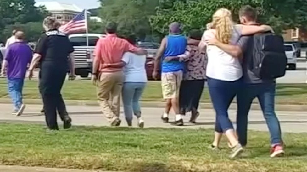 People walk away from a building in this still image taken from video following the shooting Virginia Beach, 31 May 31