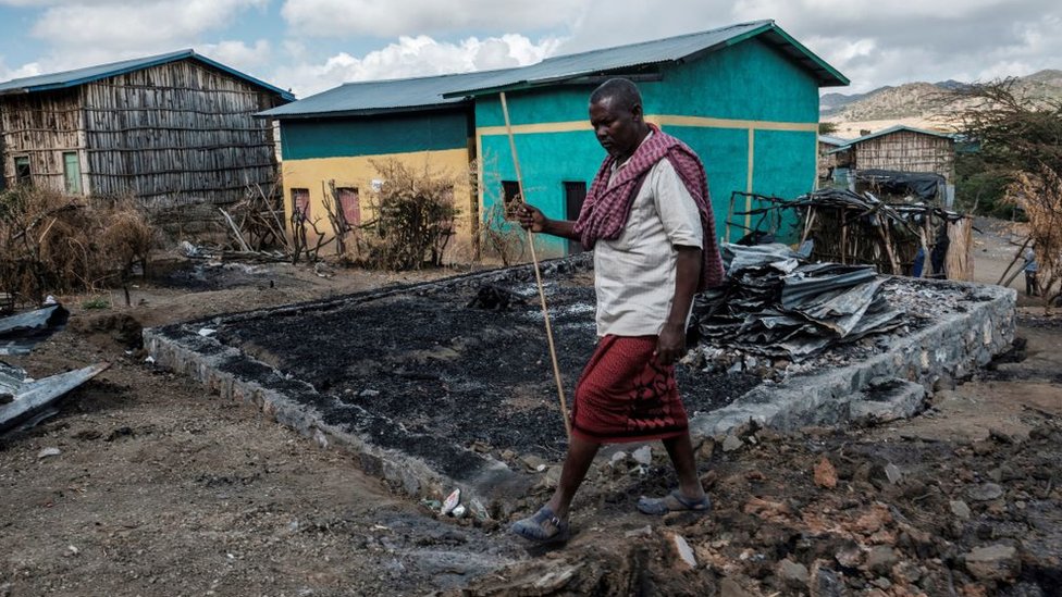 أديس سيساي ، 49 عاماً، يسير أمام منزله المدمر في قرية بيسوبر في منطقة تيغراي الإثيوبية ، 9 ديسمبر/كانون الثاني ، 2020