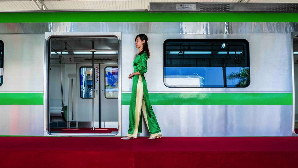 Luu Hoai Thu, a receptionist for Vietnam's Cat Linh-Ha Dong Project Management Board, walks by a model carriage on display for public consultation on 17 November 2015