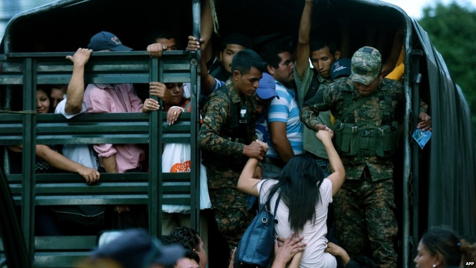 Солдаты охраняют автомобиль, который используется для перевозки людей в Сан-Сальвадоре 29 июля 2015 года, на третий день транспортной забастовки в Сальвадоре из-за отсутствия безопасности в стране, охваченной насилием.