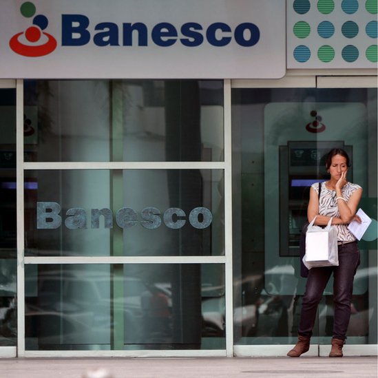 Una mujer ante un banco en Venezuela.